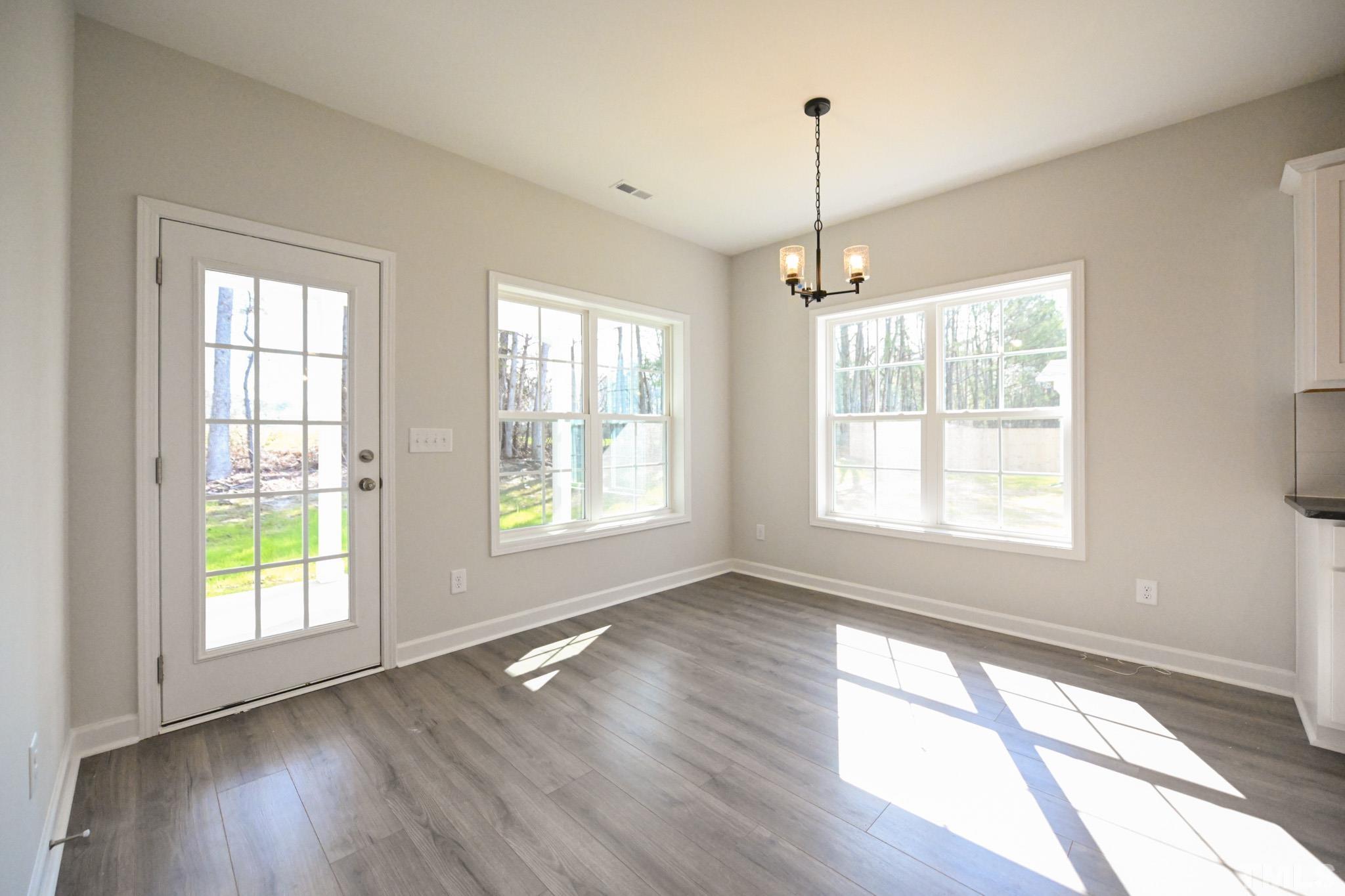 23 Chris Todd Way Angier, NC 27501 - Photo 12 of 28 a view of an empty room with wooden floor and a window