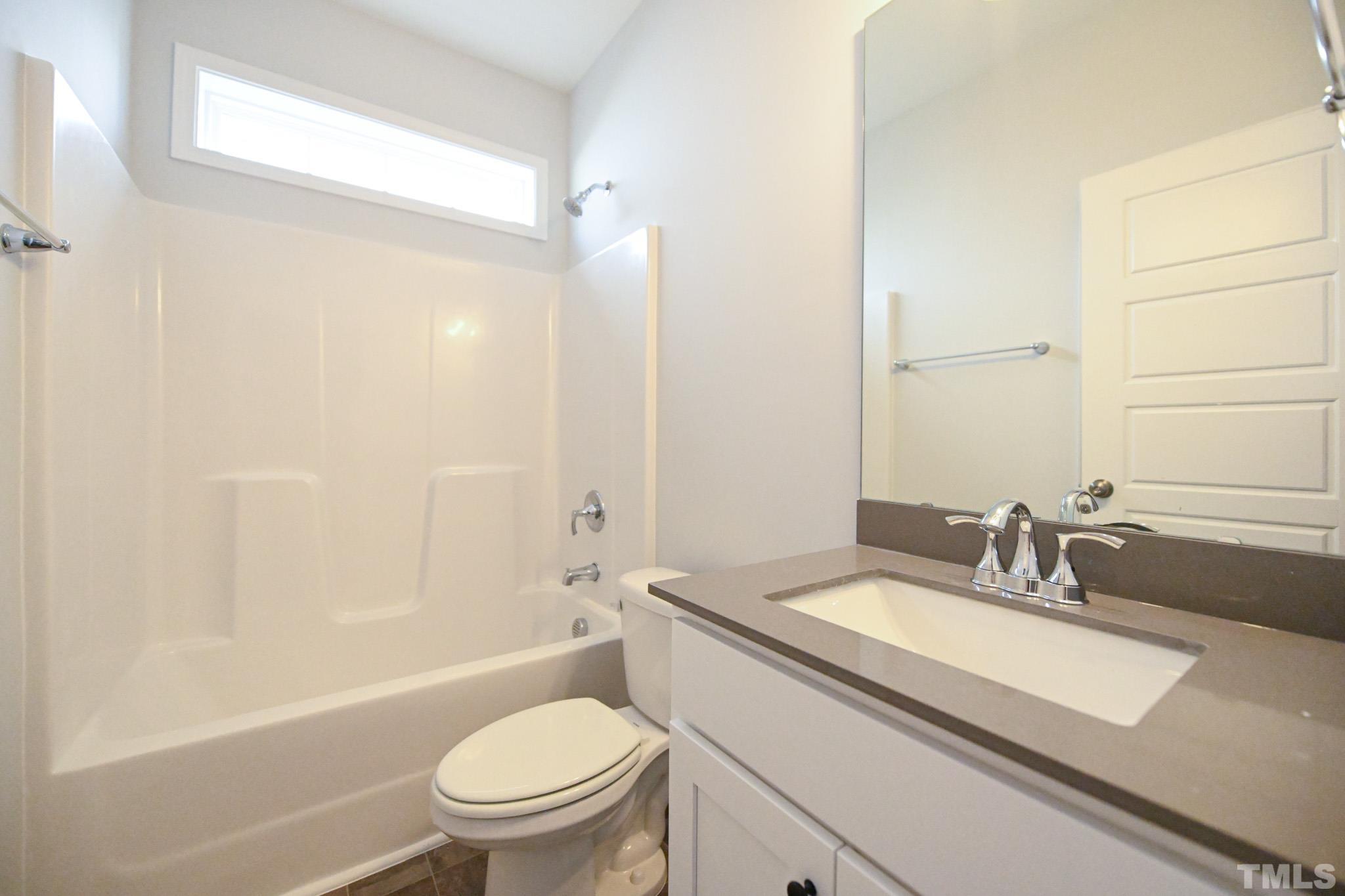 23 Chris Todd Way Angier, NC 27501 - Photo 22 of 28 a bathroom with a granite countertop sink a toilet and shower