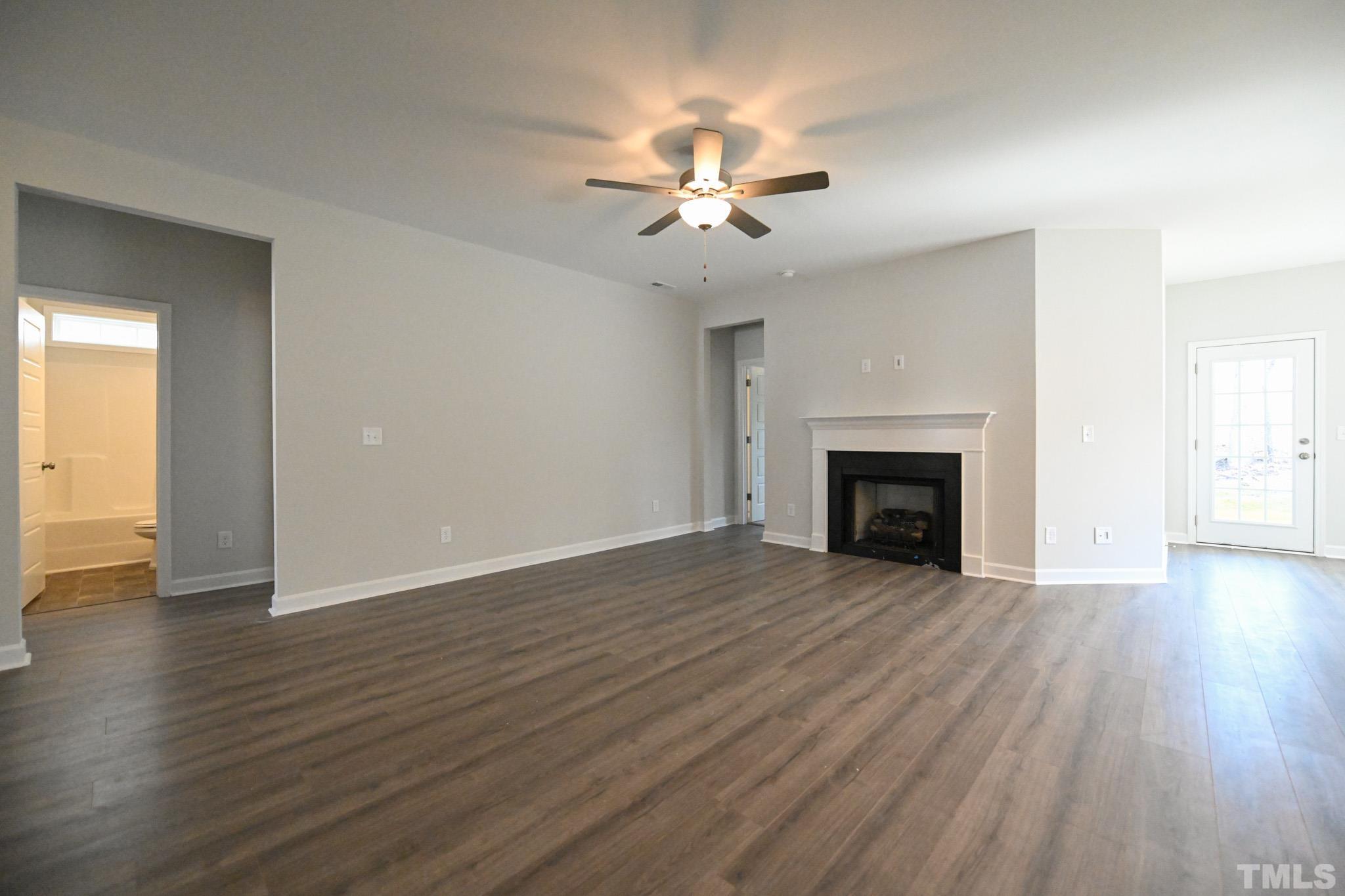 23 Chris Todd Way Angier, NC 27501 - Photo 5 of 28 a view of an empty room with wooden floor fireplace and a window