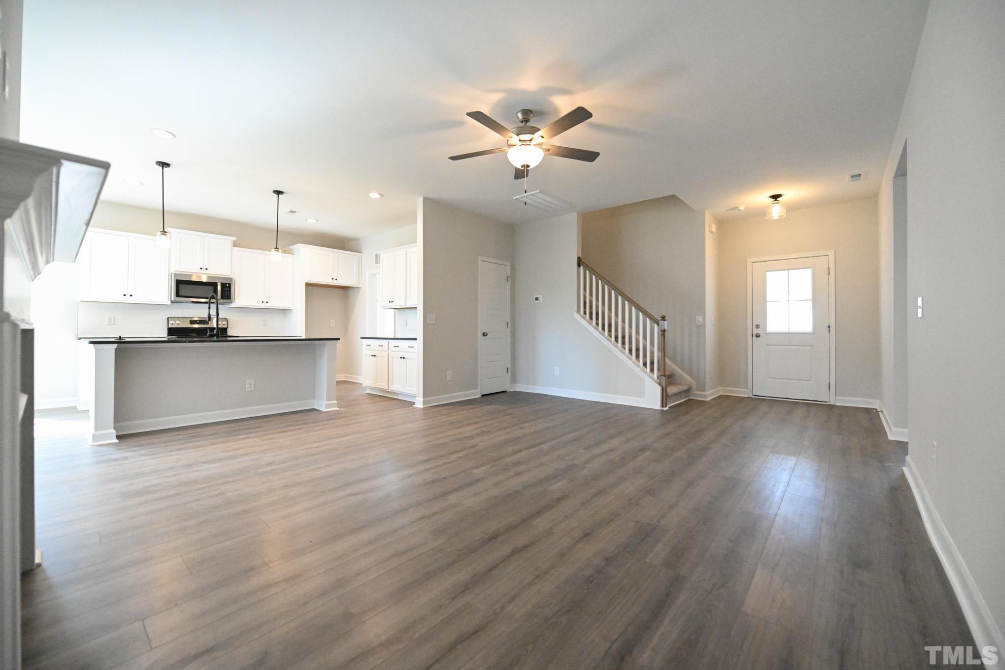 23 Chris Todd Way Angier, NC 27501 - Photo 7 of 28 a view of a kitchen with a refrigerator a ceiling fan and wooden floor