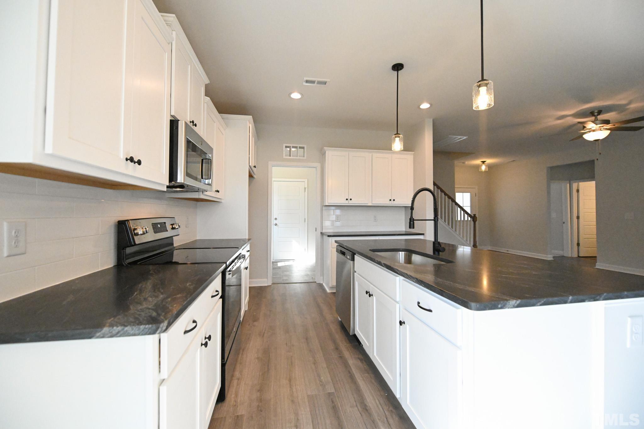 23 Chris Todd Way Angier, NC 27501 - Photo 9 of 28 a kitchen with granite countertop a sink a counter top space appliances and cabinets