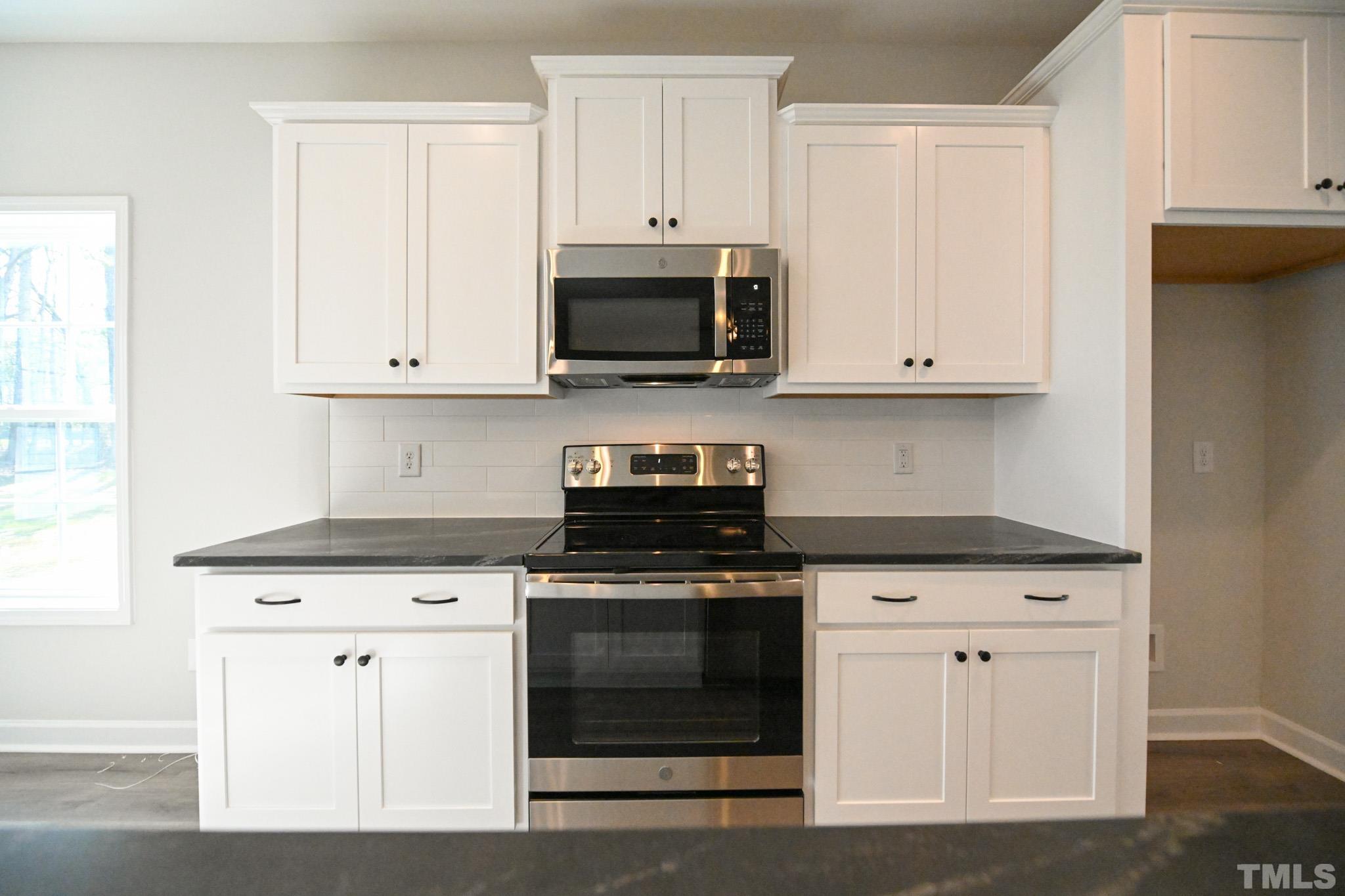 23 Chris Todd Way Angier, NC 27501 - Photo 10 of 28 a kitchen with white cabinets and stainless steel appliances