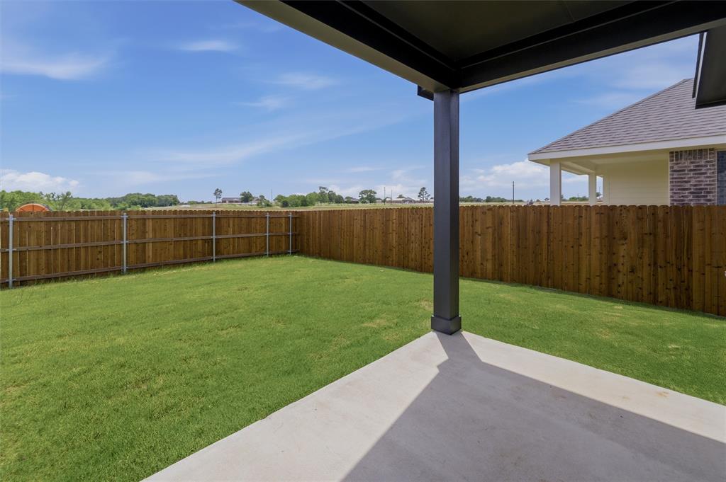 3504 Helena Street Gainesville, TX 76240 - Photo 15 of 19 Expansive backyard featuring a covered patio, manicured lawn, and privacy fencing