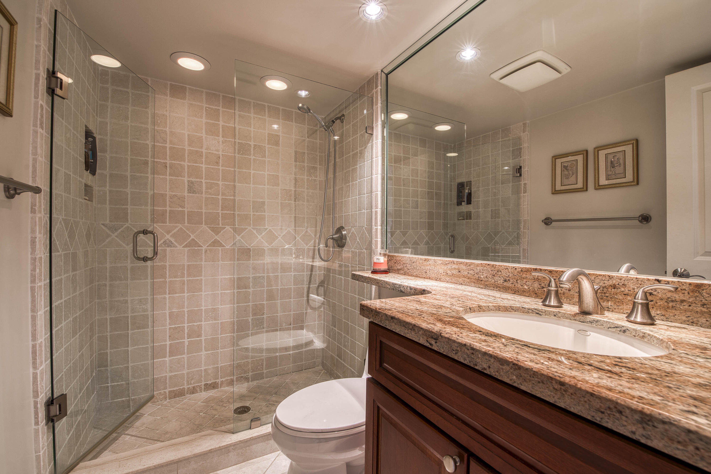 4200 North Ocean Drive, Unit 11405 Singer Island, FL 33404 - Photo 15 of 26 a bathroom with a granite countertop sink a toilet a mirror and shower