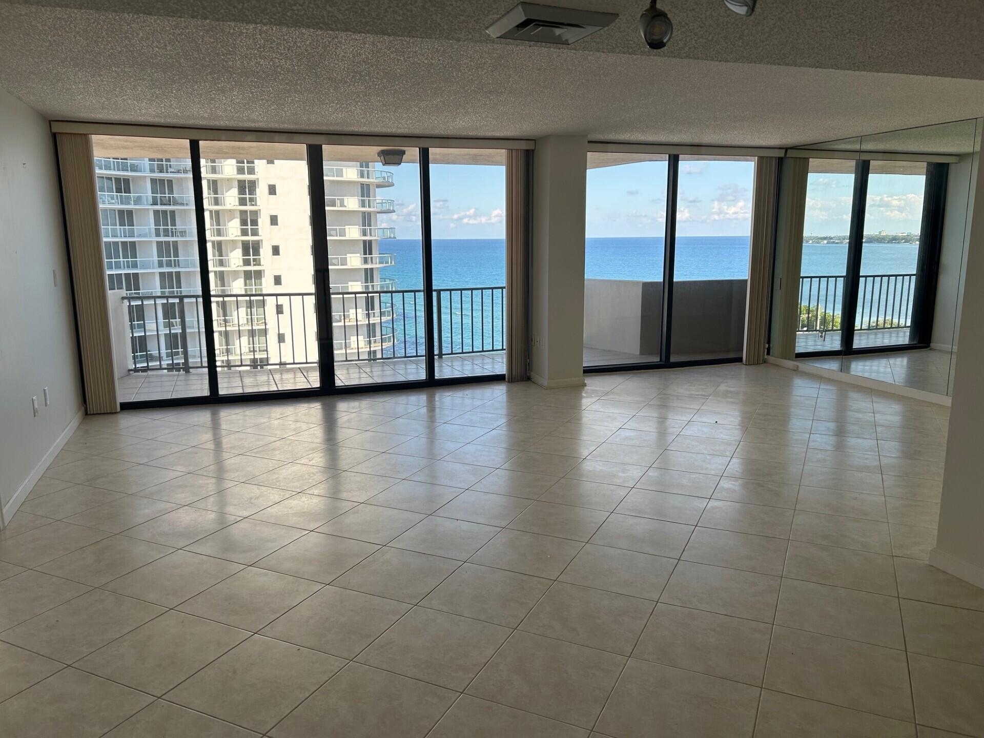 4200 North Ocean Drive, Unit 11405 Singer Island, FL 33404 - Photo 5 of 26 a view of an empty room with a floor to ceiling window and chandelier