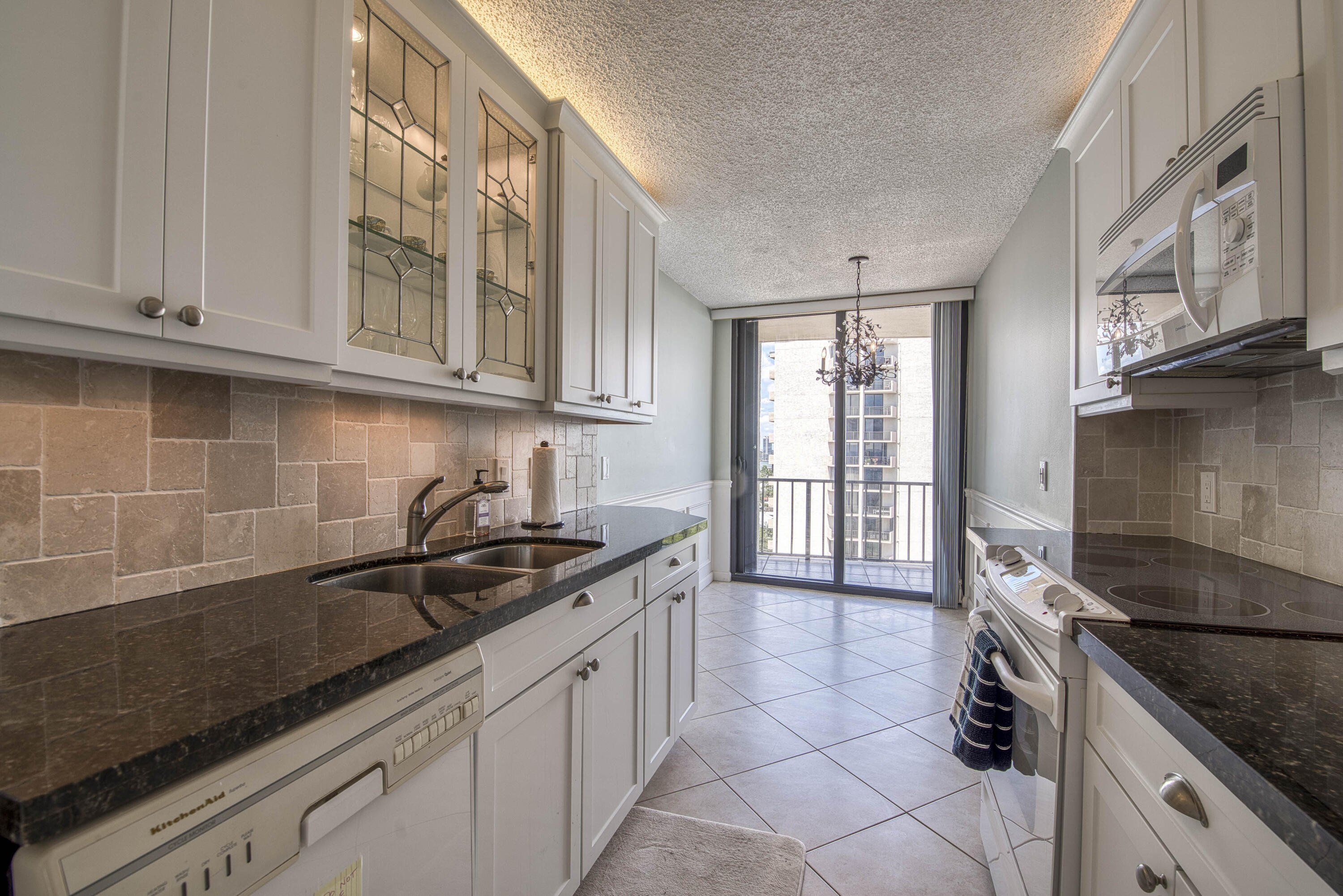 4200 North Ocean Drive, Unit 11405 Singer Island, FL 33404 - Photo 8 of 26 a kitchen with granite countertop a sink stainless steel appliances and cabinets