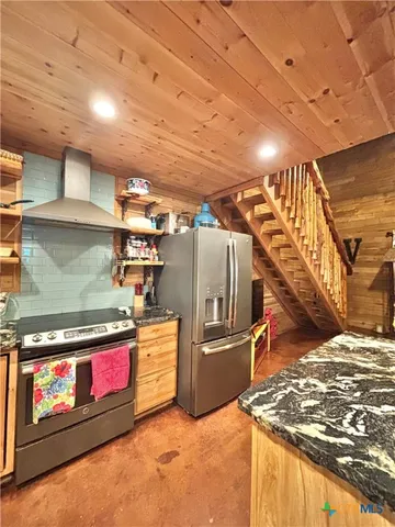 a view of a kitchen with stainless steel appliances granite countertop a stove and a sink