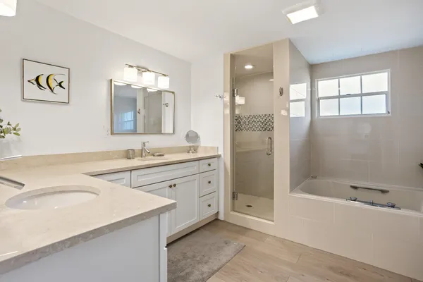 a spacious bathroom with a granite countertop sink mirror and bathtub