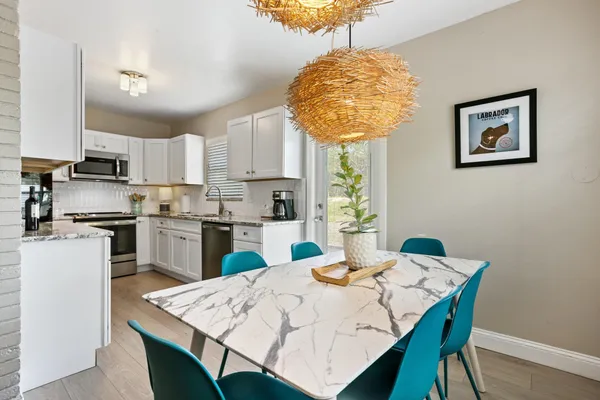 a kitchen with a table chairs and a refrigerator
