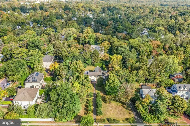 an aerial view of a house with a yard and large trees