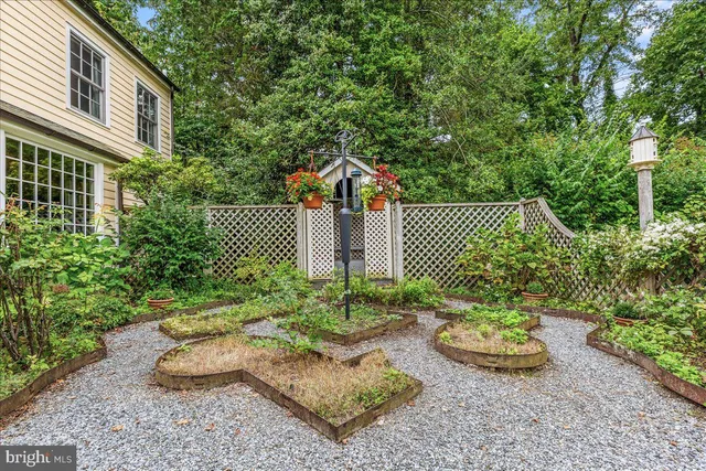 an aerial view of a house with swimming pool a yard and a large tree