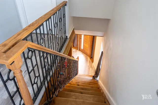a view of staircase with wooden floor and white walls