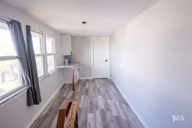 a view of a kitchen with wooden floor and electronic appliances