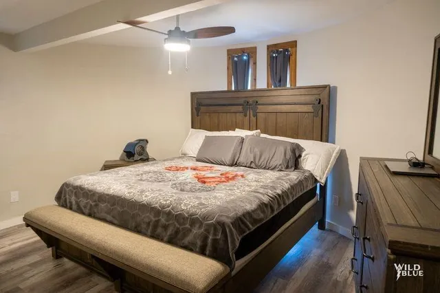 a bedroom with bed and wooden floor