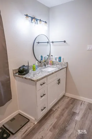 a bathroom with a granite countertop sink and a mirror