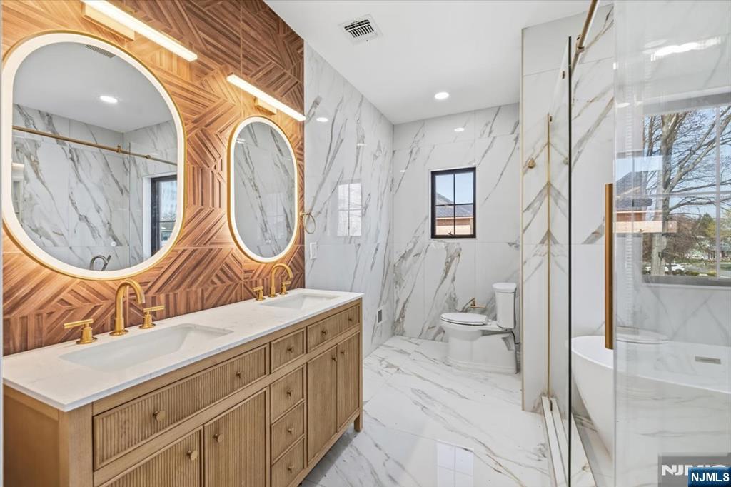 150 Howland Avenue River Edge, NJ 07661 - Photo 17 of 45 a bathroom with a sink a mirror a bathtub and a shower