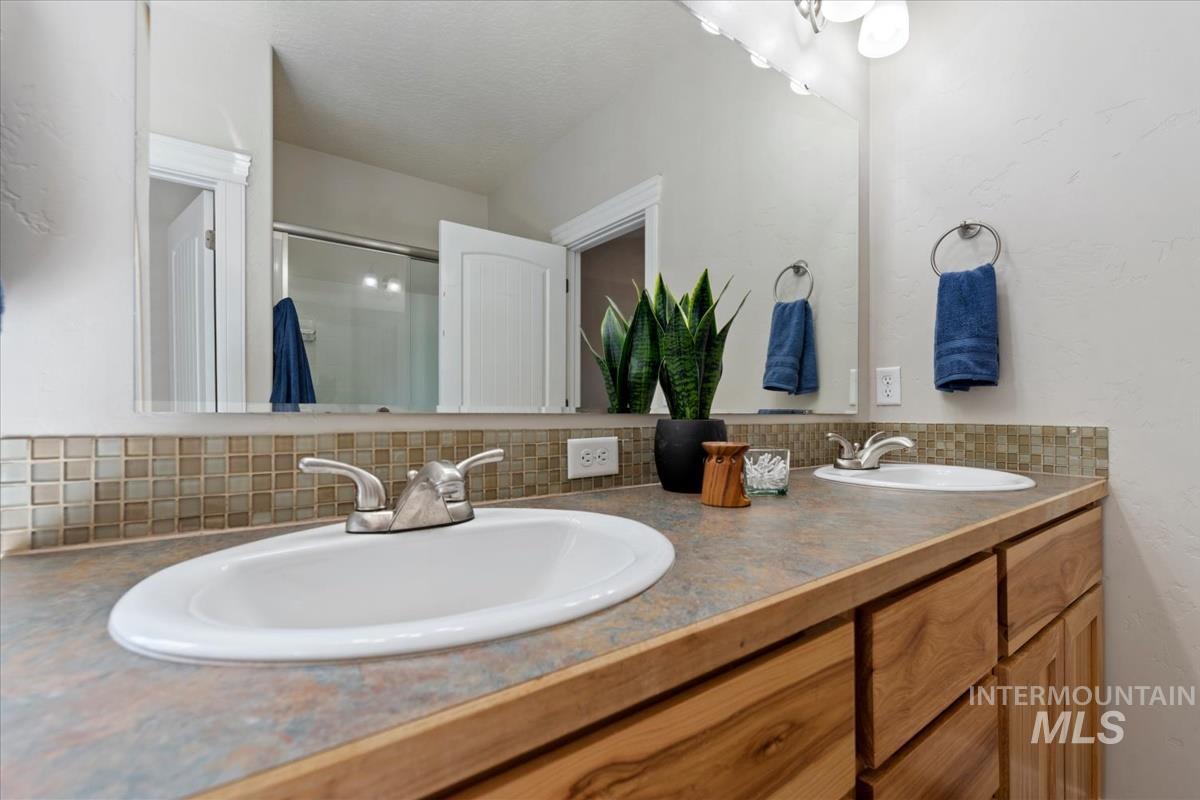 640 Southwest Miner Street Mountain Home, ID 83647 - Photo 22 of 35 Double vanity featuring undermount sinks, brushed nickel faucets, and a full-width mirror