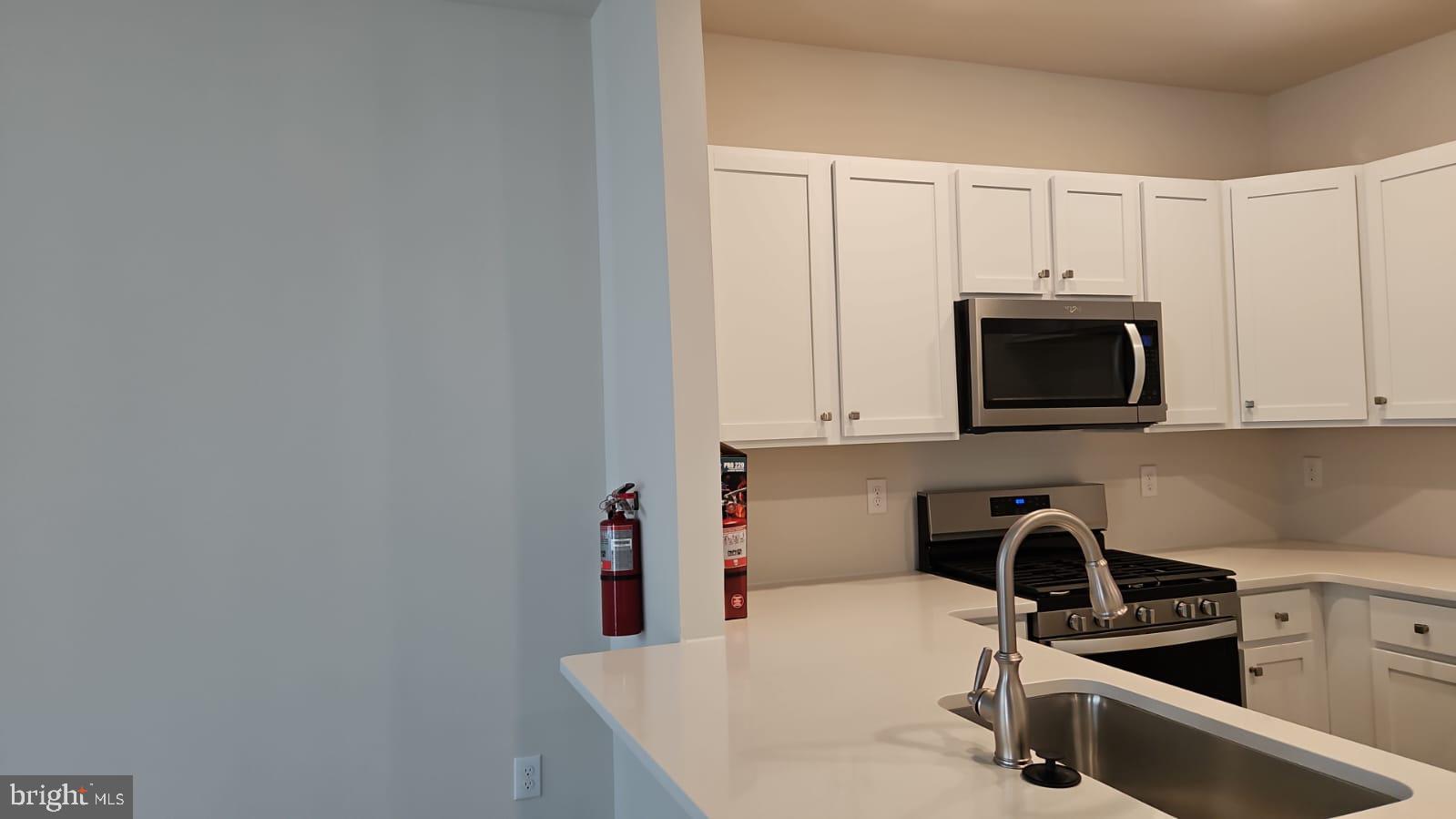 18 Elliot Lane Westampton, NJ 08060 - Photo 8 of 38 a kitchen with stainless steel appliances a sink a stove a microwave a sink and cabinets