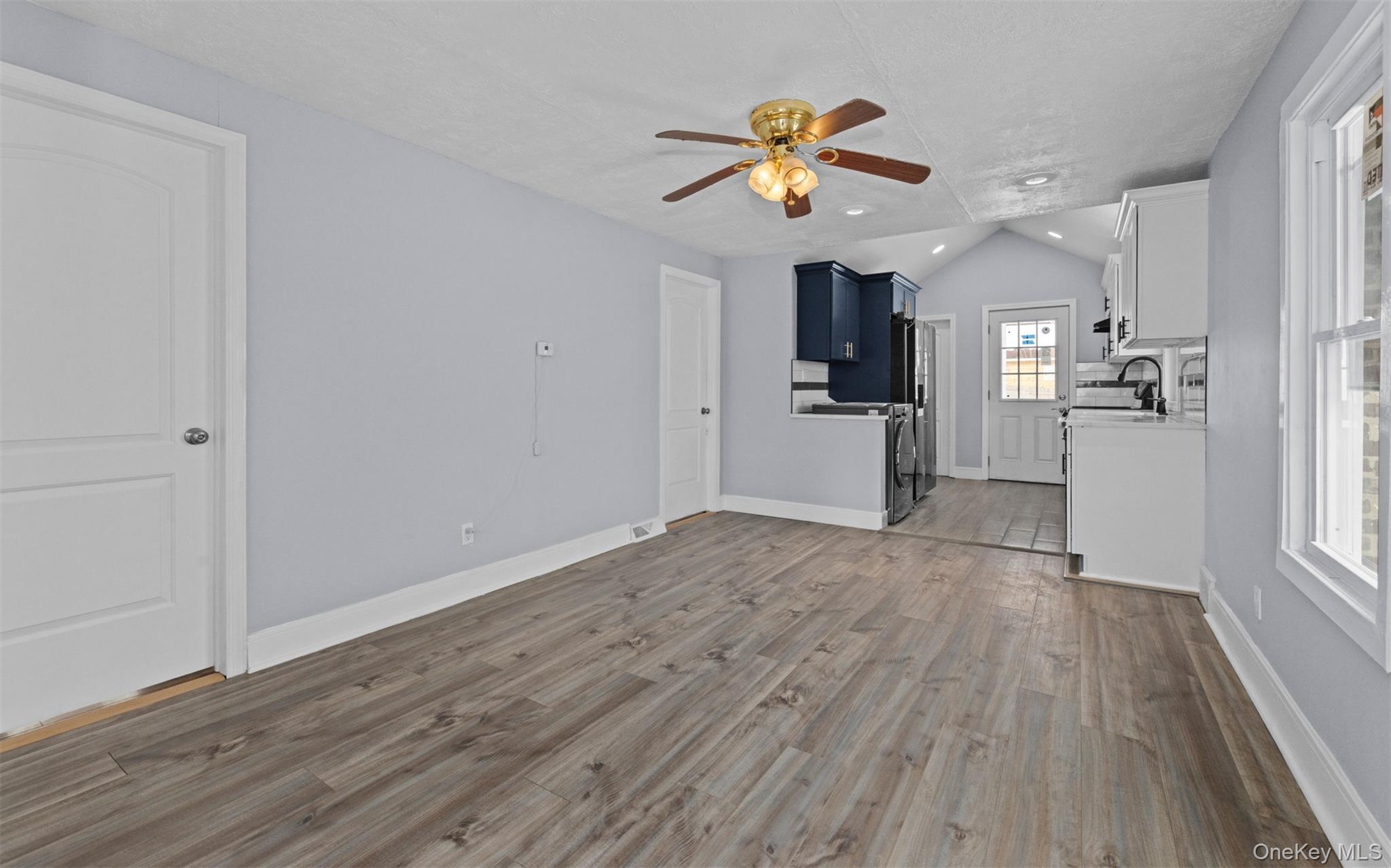 61 Eastview Road Ronkonkoma, NY 11779 - Photo 3 of 27 a view of empty room with wooden floor and ceiling fan