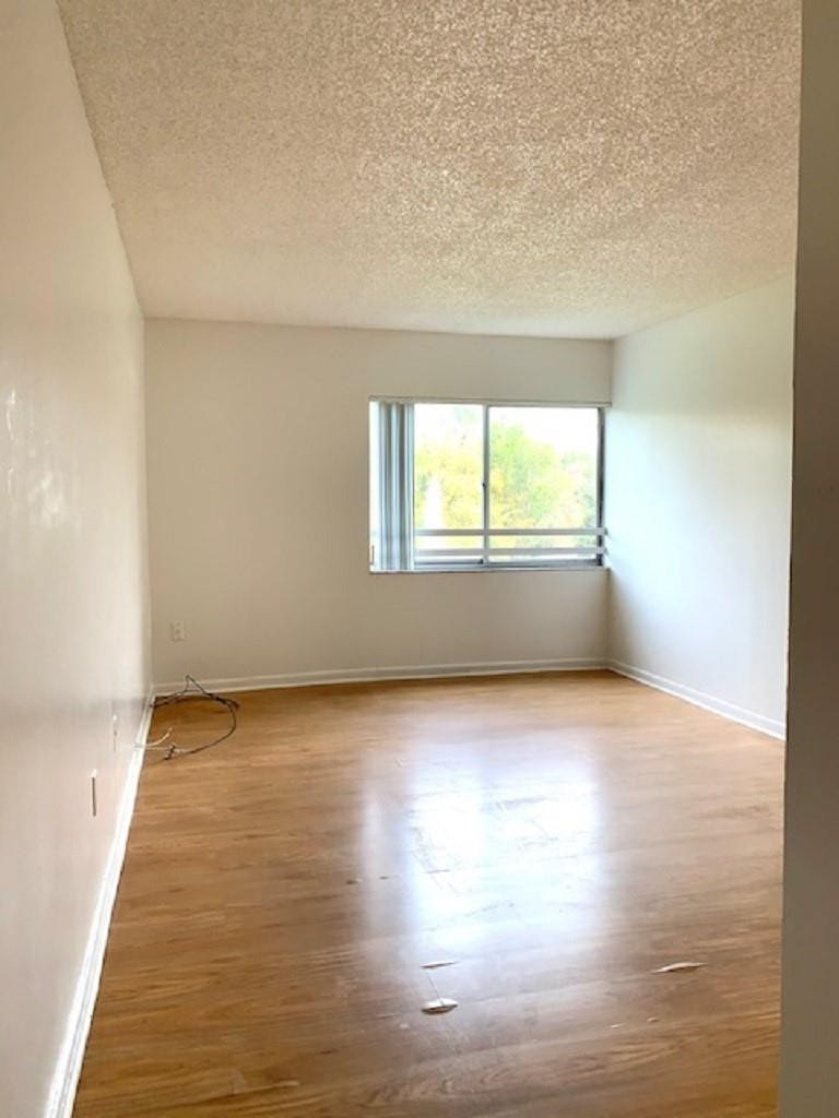 721 North Pine Island Road, Unit 213 Plantation, FL 33324 - Photo 12 of 34 an empty room with wooden floor and windows