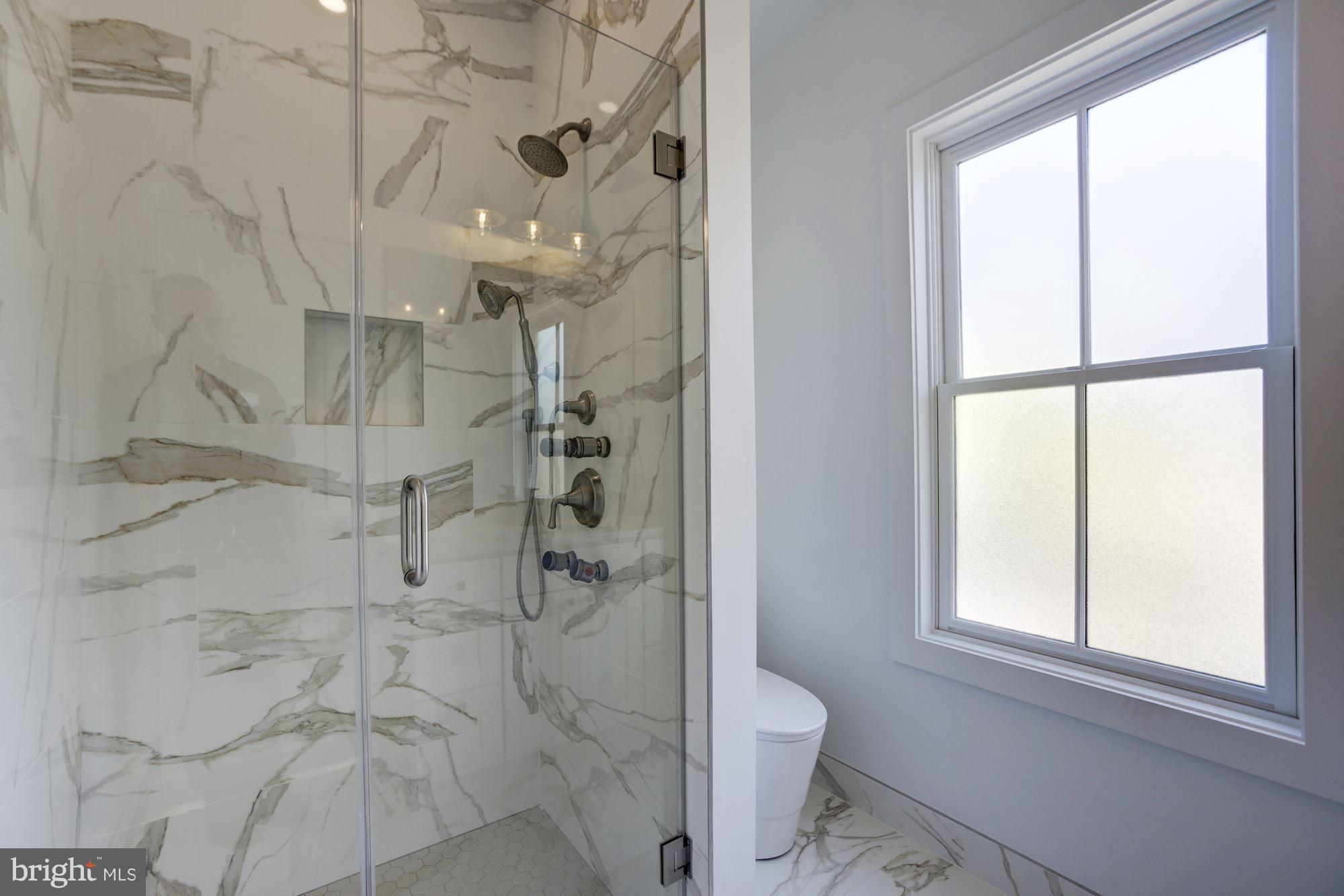 401 11th Street Southeast Washington, DC 20003 - Photo 15 of 27 a bathroom with a granite countertop shower a toilet and a window
