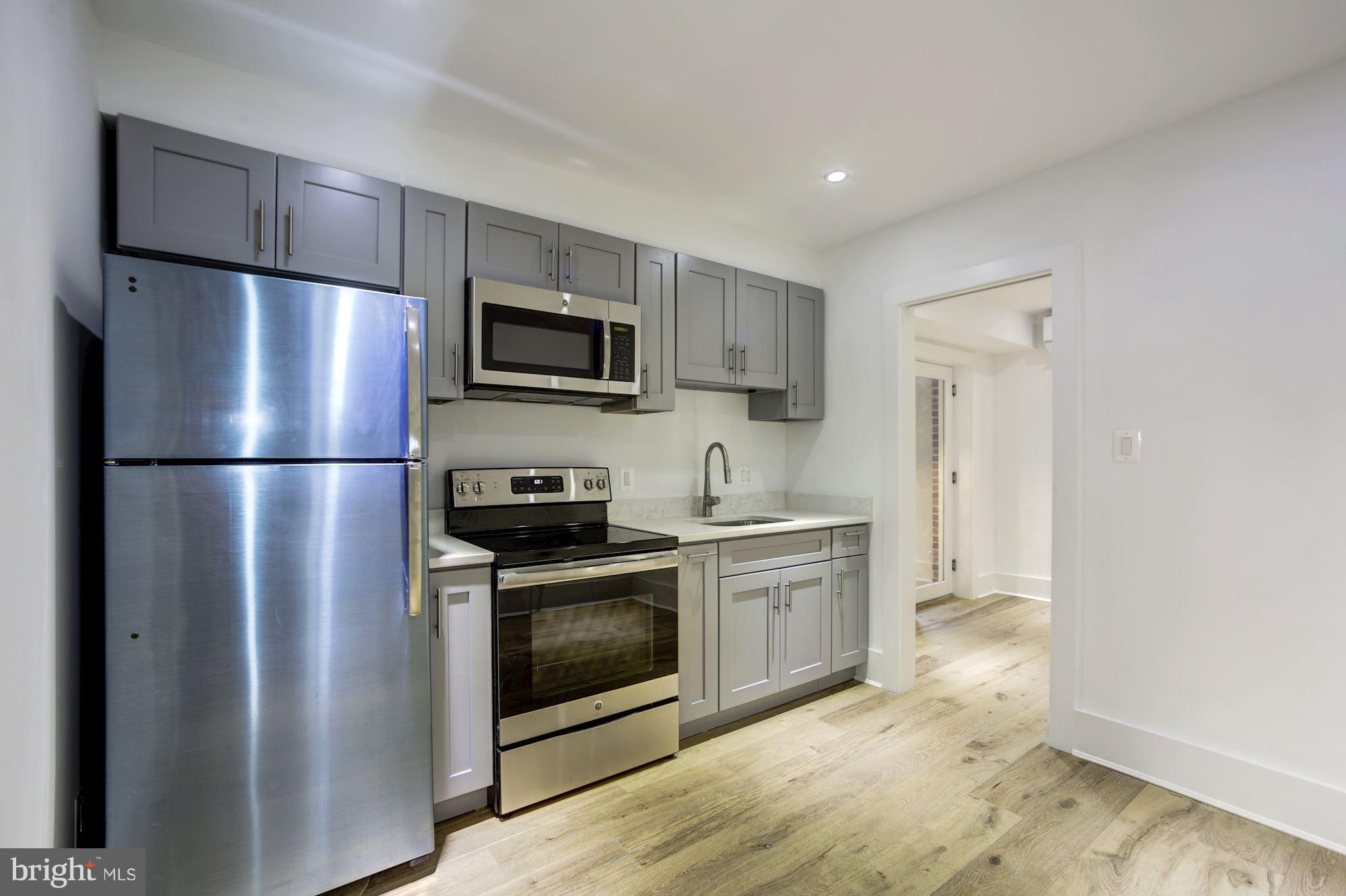401 11th Street Southeast Washington, DC 20003 - Photo 22 of 27 a kitchen with stainless steel appliances granite countertop a refrigerator stove a sink and a microwave