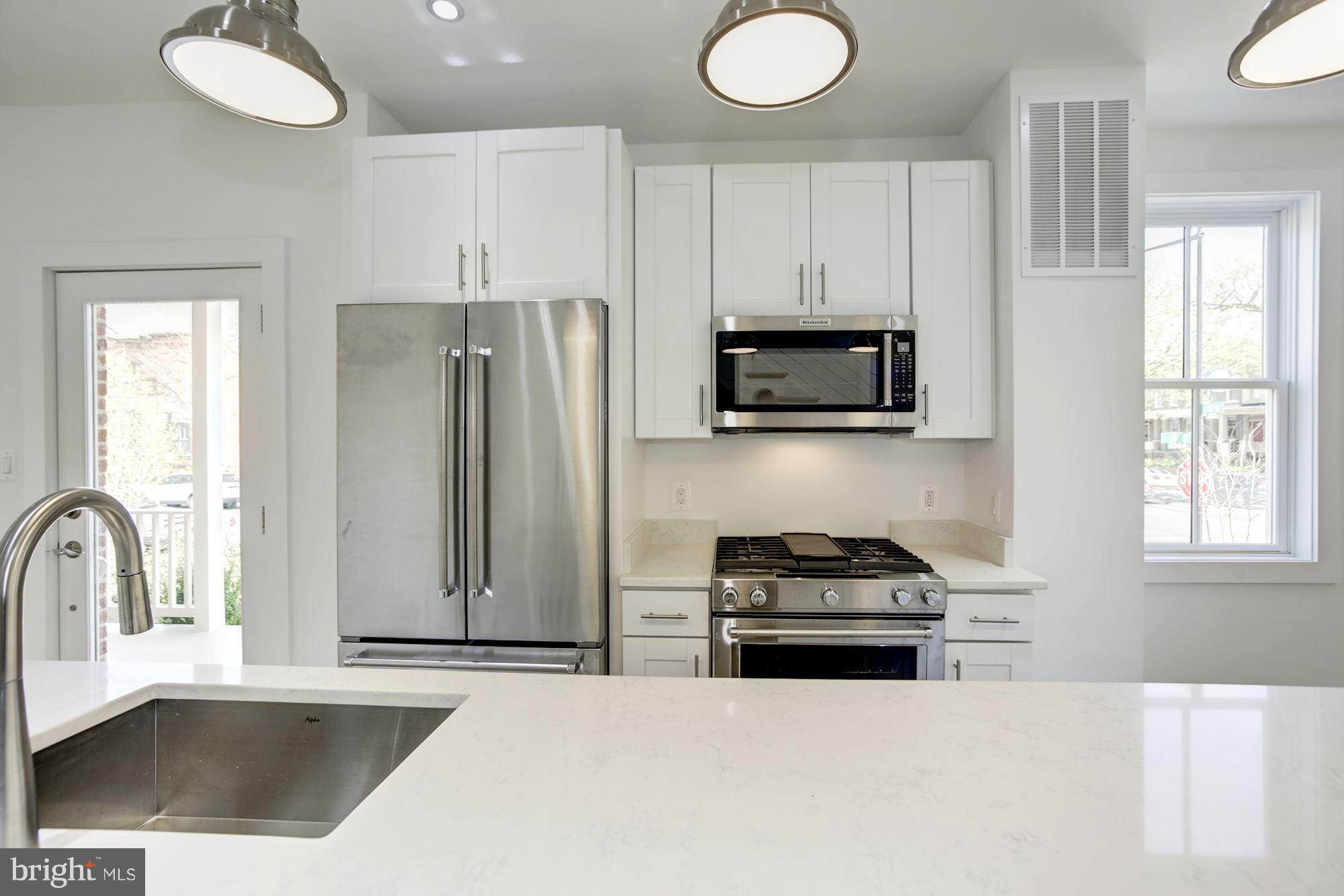 401 11th Street Southeast Washington, DC 20003 - Photo 10 of 27 a kitchen with granite countertop a stove a sink and a refrigerator