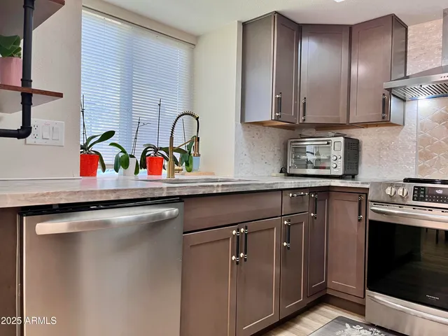 a kitchen with stainless steel appliances granite countertop a sink and a stove