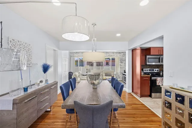 a dining room with stainless steel appliances granite countertop furniture and a kitchen view