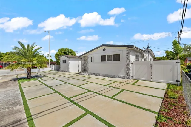 a view of a white house with a yard