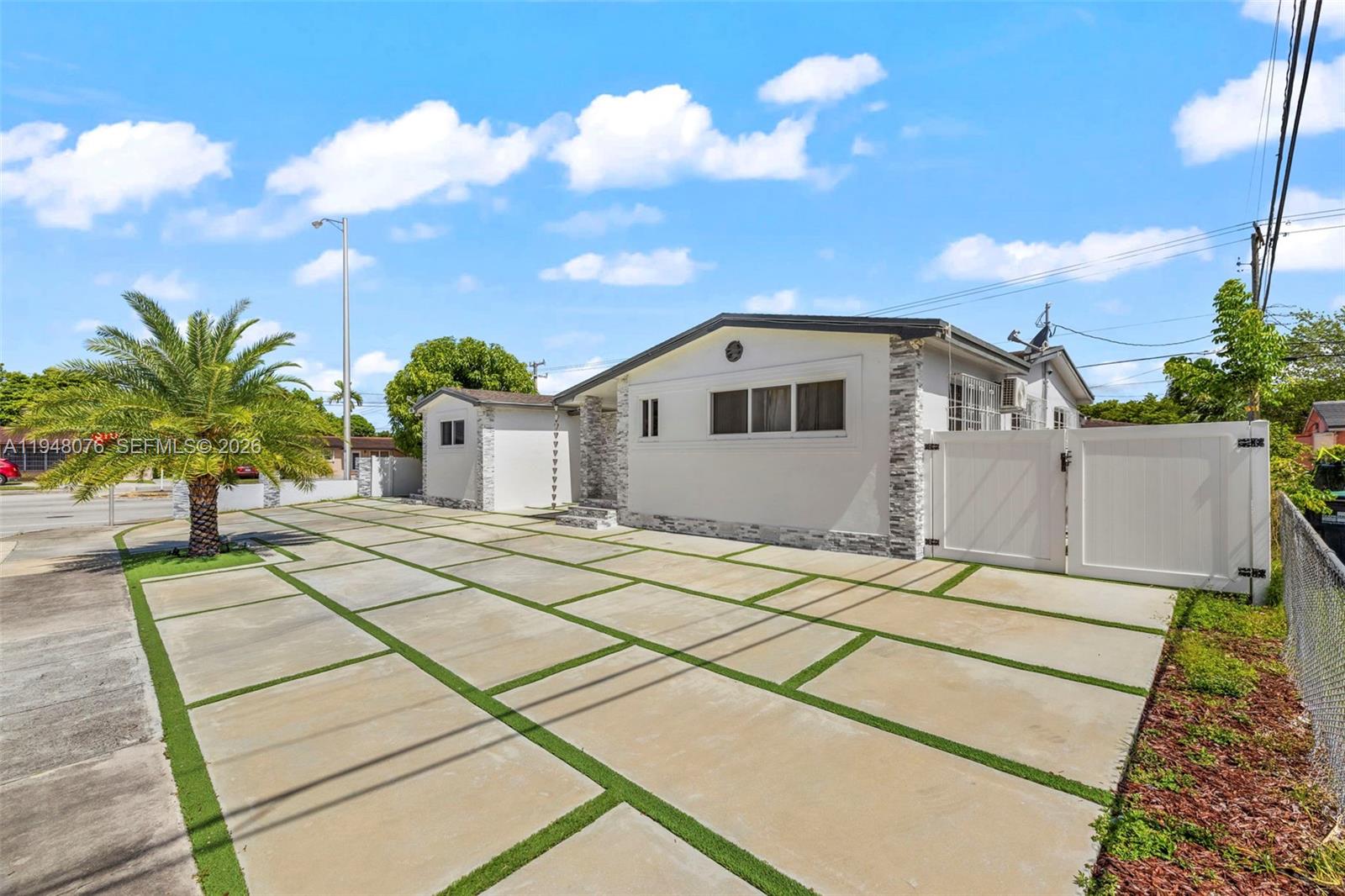 8631 Southwest 16th Terrace Miami, FL 33155 - Photo 2 of 39 a view of a white house with a yard