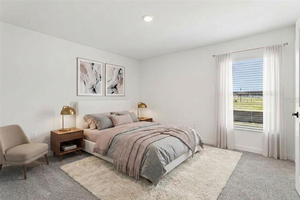 12249 Shafton Road Spring Hill, FL 34608 - Photo 10 of 12 a spacious bedroom with a bed a couch and a window