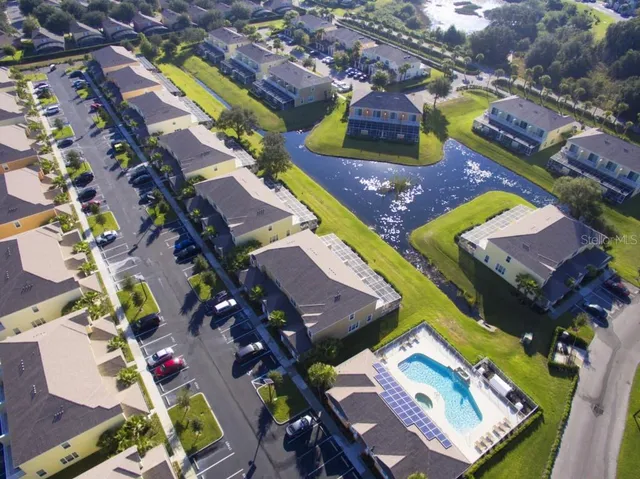a front view of a house with a yard and palm trees