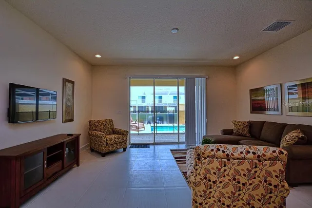 a living room with furniture a flat screen tv and a window