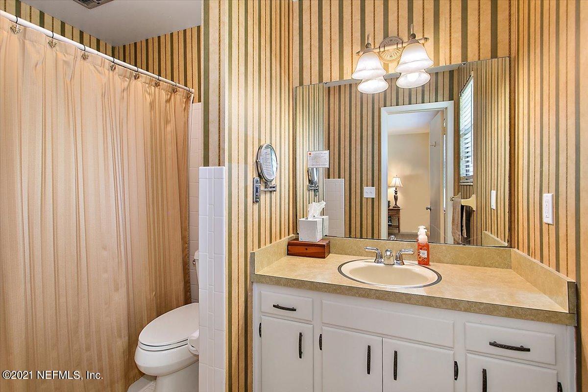 4064 Heath Road Jacksonville, FL 32277 - Photo 14 of 23 a bathroom with a sink a toilet and a mirror