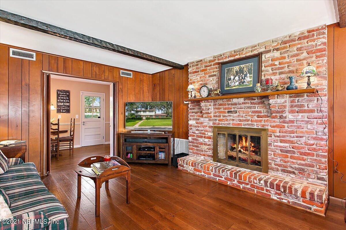 4064 Heath Road Jacksonville, FL 32277 - Photo 7 of 23 a living room with furniture a flat screen tv and a fireplace