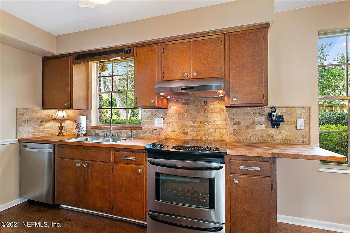 4064 Heath Road Jacksonville, FL 32277 - Photo 8 of 23 a kitchen with granite countertop a sink stove and cabinets