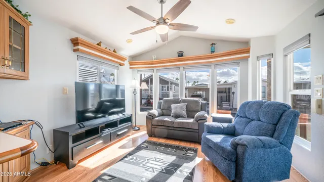 a living room with furniture a flat screen tv and a floor to ceiling window