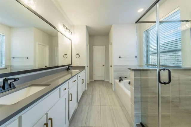a bathroom with a granite countertop sink two mirror and shower