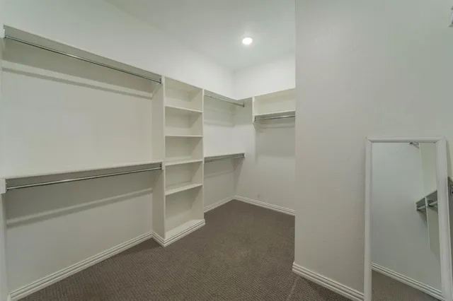 a view of walk in closet with empty racks