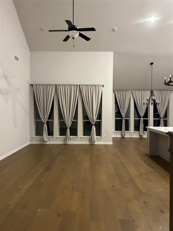 4304 Expedition Drive Oak Point, TX 75068 - Photo 10 of 19 Unfurnished living room featuring a ceiling fan, a chandelier, dark wood-style floors, and lofted ceiling