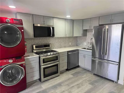 a kitchen with a refrigerator sink and cabinets