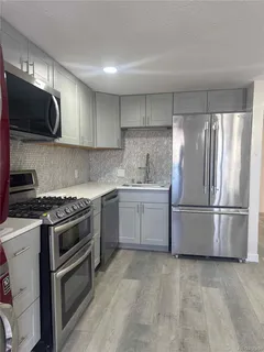 a kitchen with a stove a sink and a refrigerator