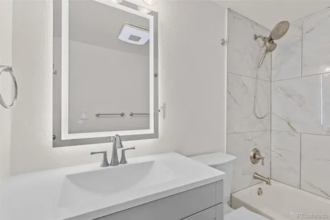 a bathroom with a sink a toilet and shower