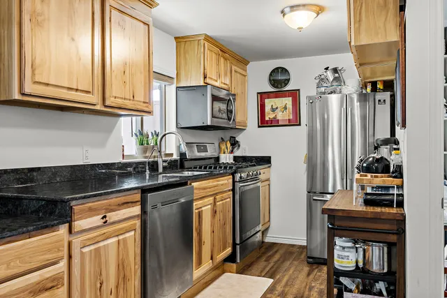 a kitchen with stainless steel appliances granite countertop a refrigerator and a stove top oven