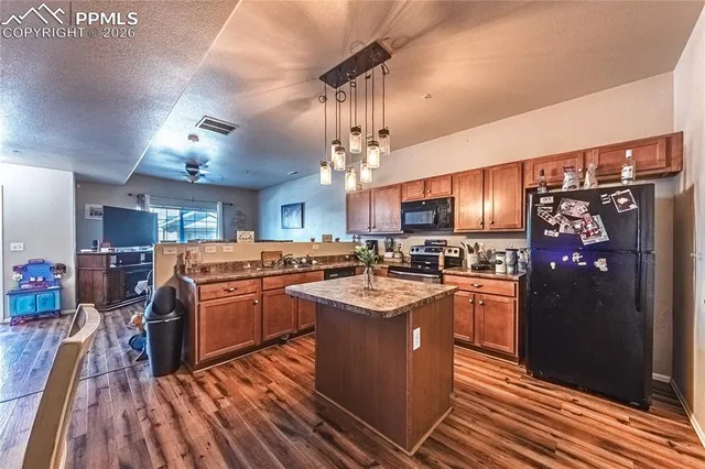 a kitchen with stainless steel appliances granite countertop a sink a stove and a refrigerator