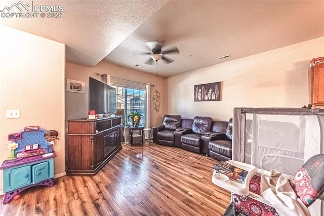 a living room with furniture and a wooden floor