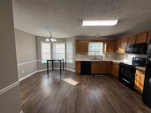 a kitchen with a wooden floor a sink and a window
