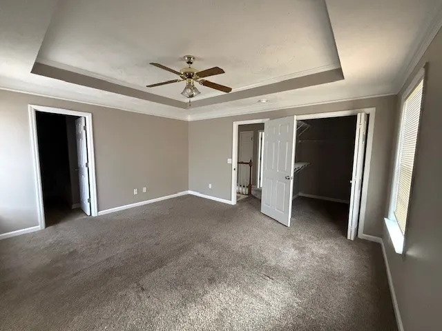 a view of a big room with closet and a ceiling fan