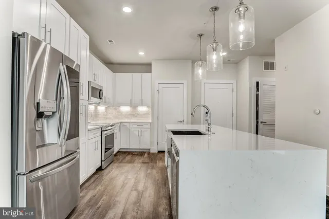 a kitchen with stainless steel appliances a refrigerator sink and cabinets